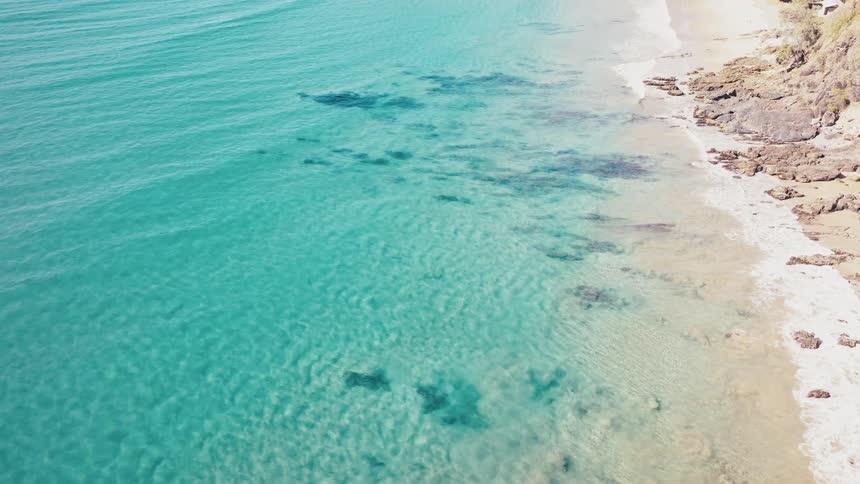 Aerial view of a beach with crystal clear turquoise waters