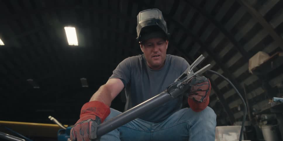 Man with red gloves holding a heated metal