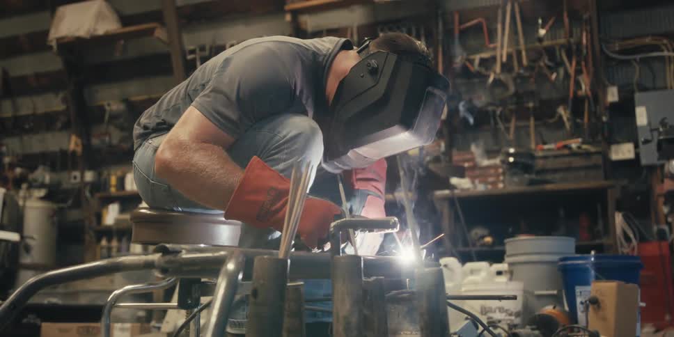Man in mask welding a metal piece