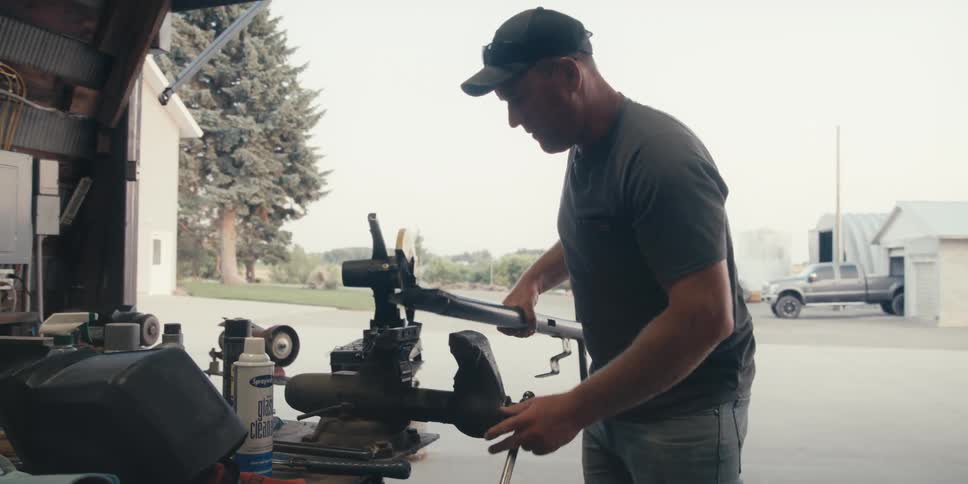 A man removes a tool from the vice and hands it to someone