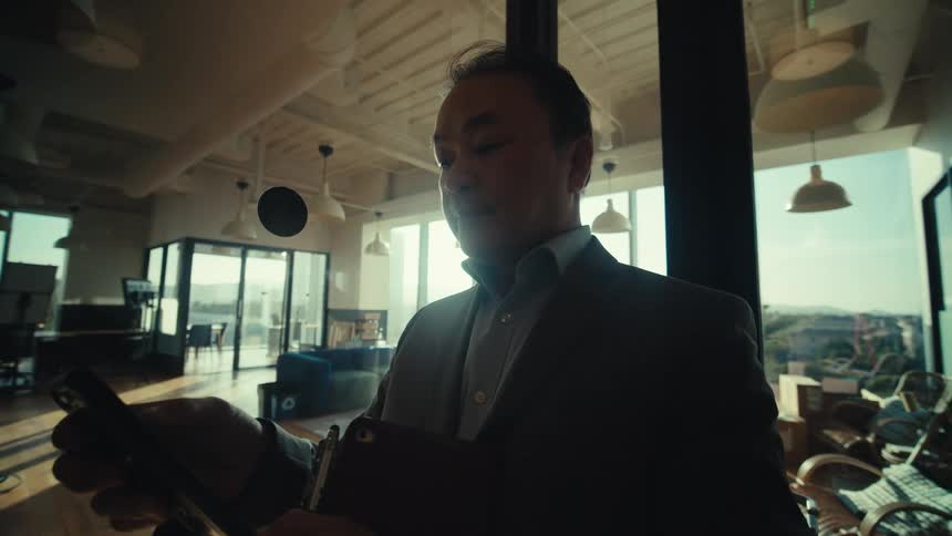 Formally dressed man interacts with his cell phone