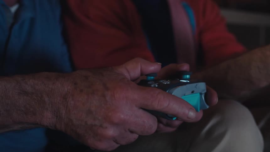 Two men are using a controller to play video games
