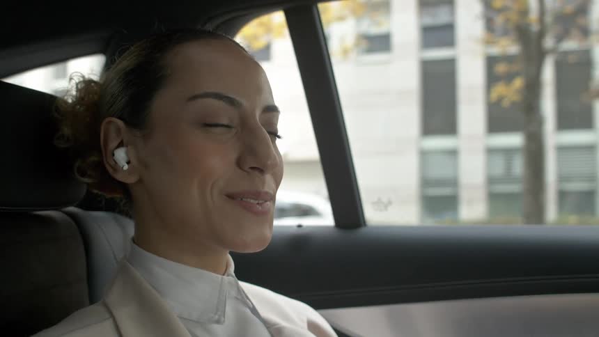 A woman takes a call with her earbuds