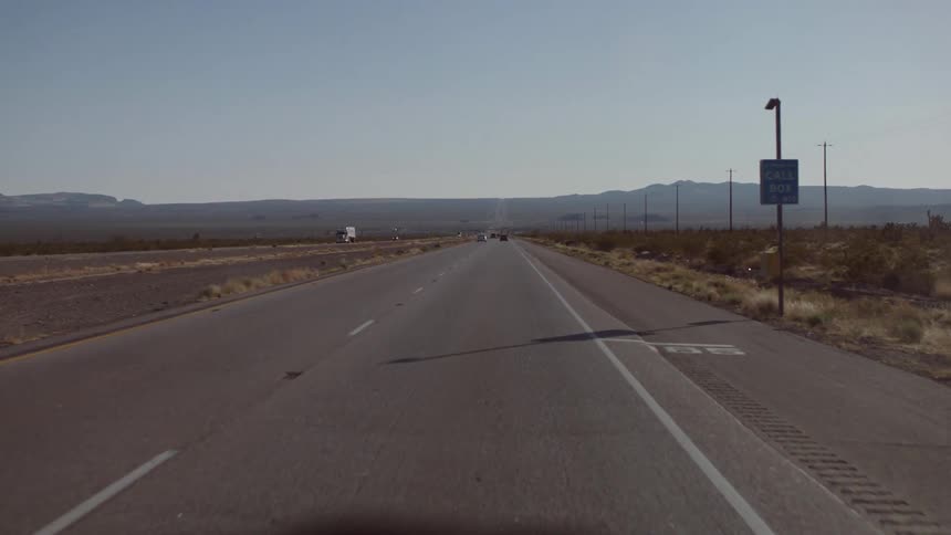 Car drives down desert road