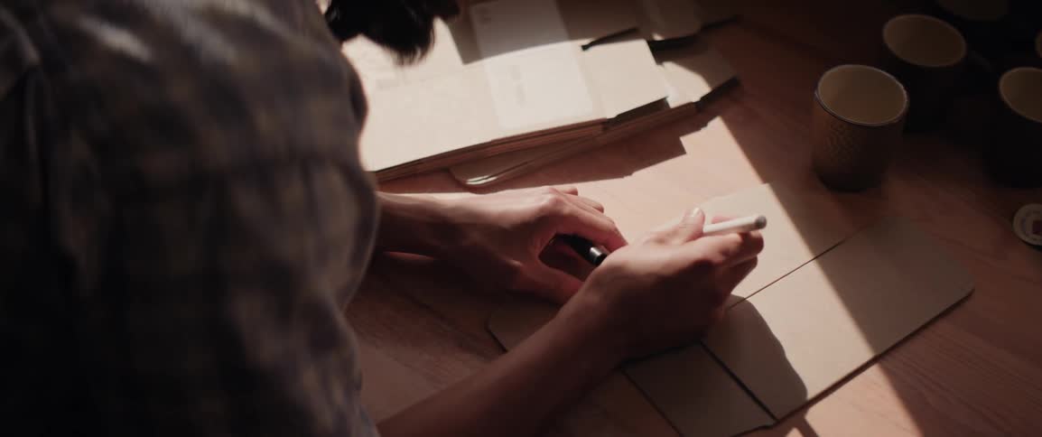 A man writes on a cardboard box