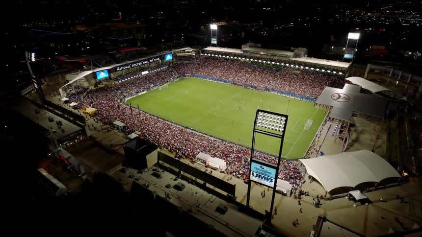 An aerial view of toyota stadium at night showcases a packed stadium a brightly illuminated soccer field and a lively atmosphere surrounding a match