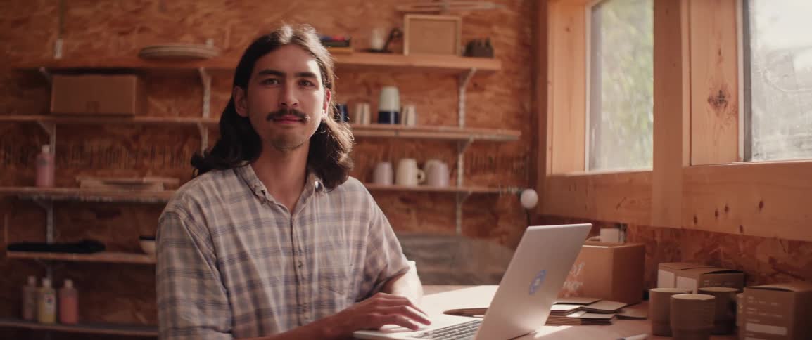 Portrait of a man sitting at his workbench while using a computer