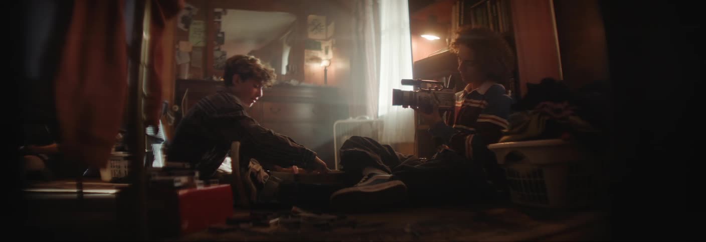 A teenager is using a camera inside