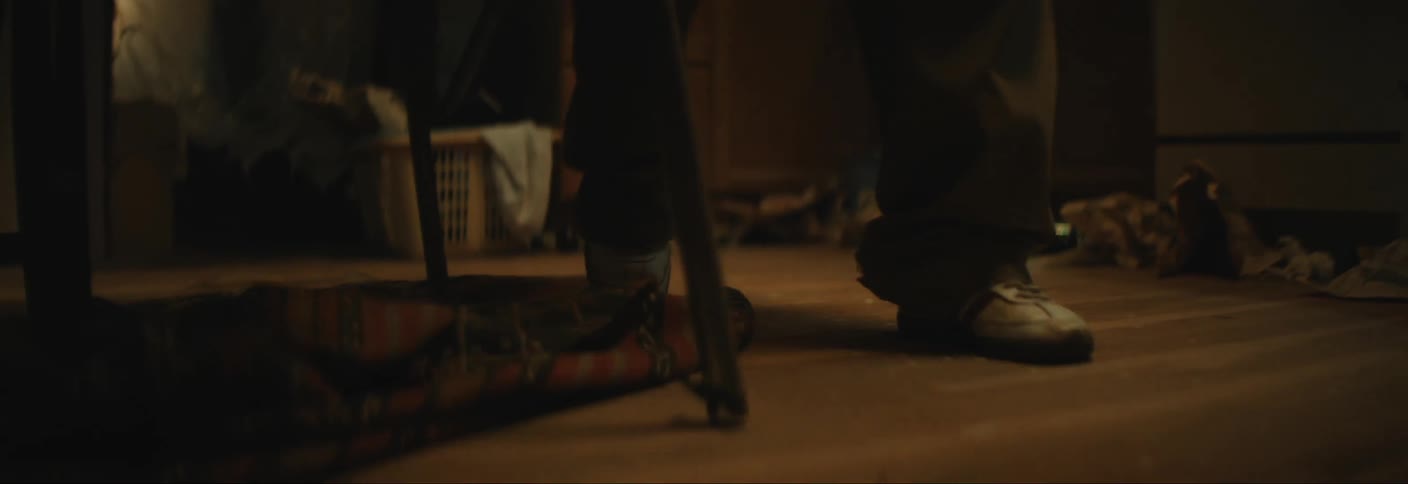 A person trips and drops a glass bottle on the floor