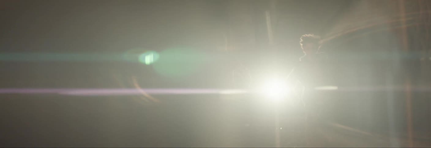 Two kids run from a vehicle with bright headlights illuminating them at night