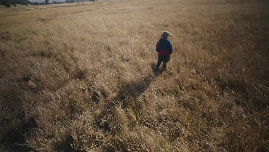 A hiker is looking around the large field