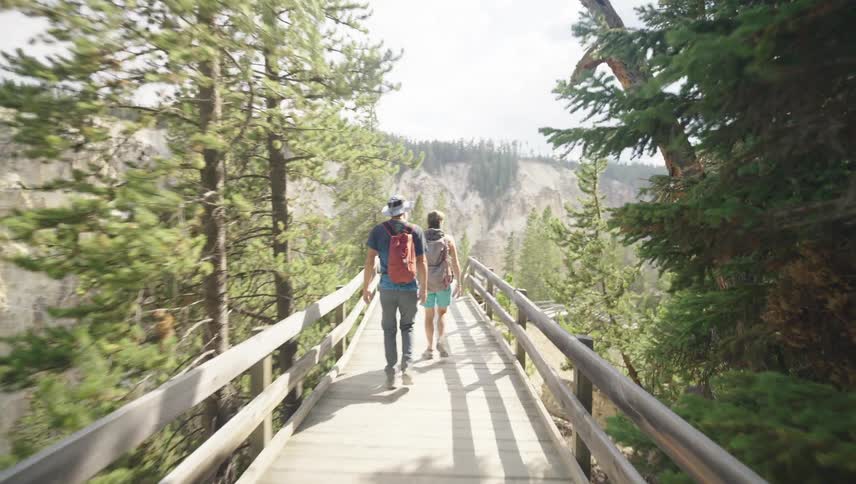 People are hiking on a wooden path on the mountain