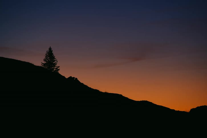 The sun is setting behind the mountain