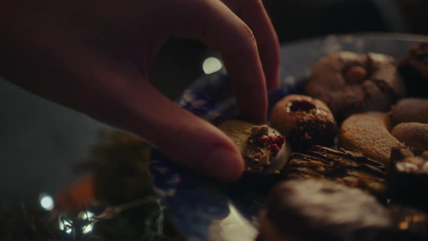 A person removes a cookie from the platter