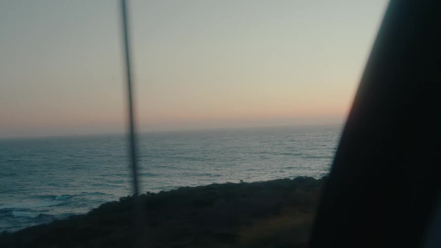 A car drives on a road by the shore