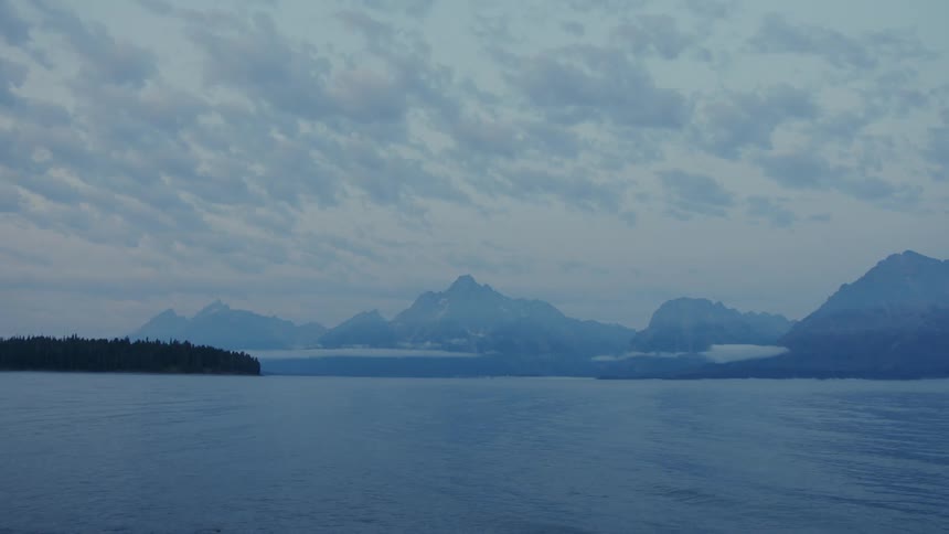 Ripples across a lake mountain landscape at blue hour