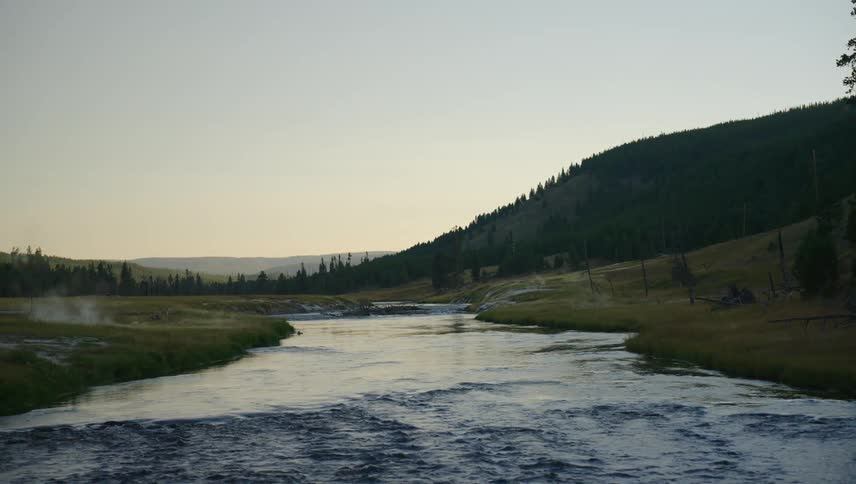 Water is flowing slowly down a river