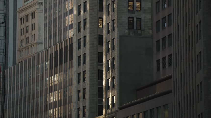 A closeup view of a row of tall office buildings with concrete facades