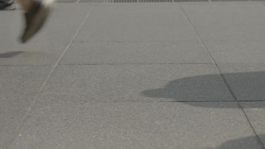 Pedestrians walk on the concrete sidewalk