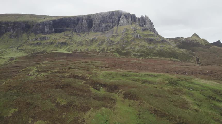 A rugged mountain landscape with rolling hills and rocky cliffs