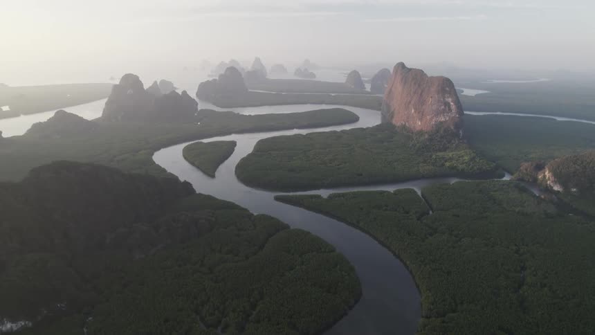 A winding river flows through a landscape of dramatic limestone cliffs