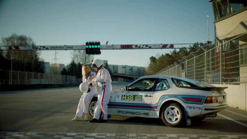 Two drivers stand by the car on the track