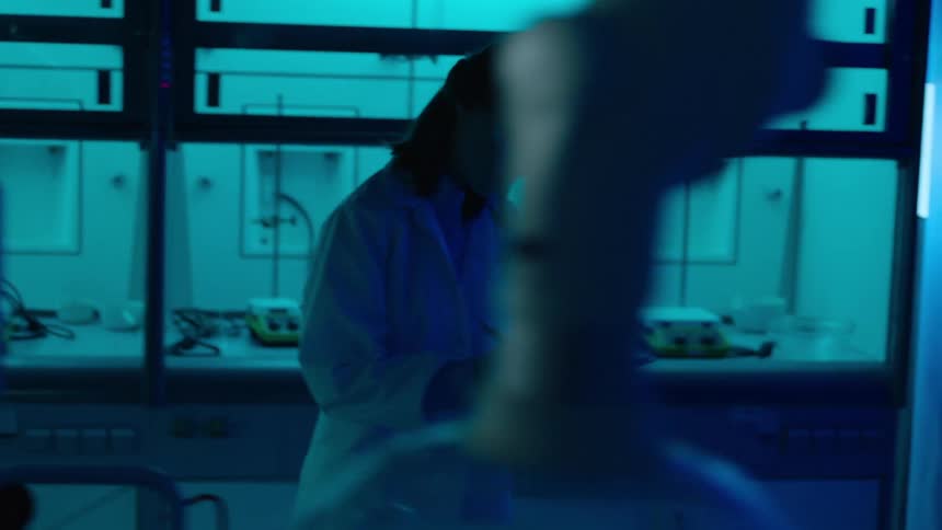 A woman takes notes while walking around the lab