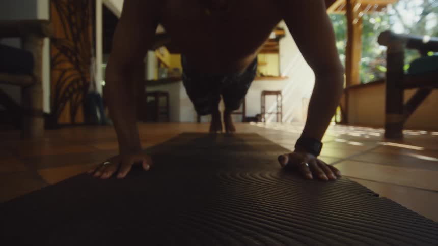 Man in a covered backyard doing pushups