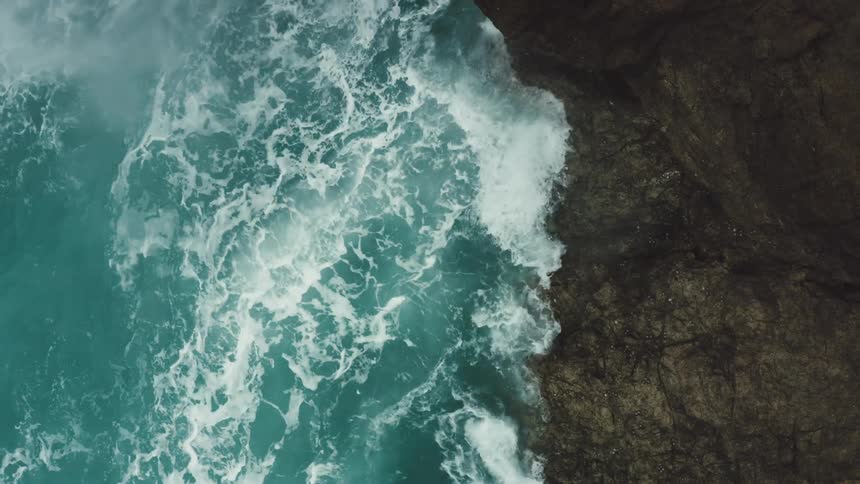 Waves crash against a cliff