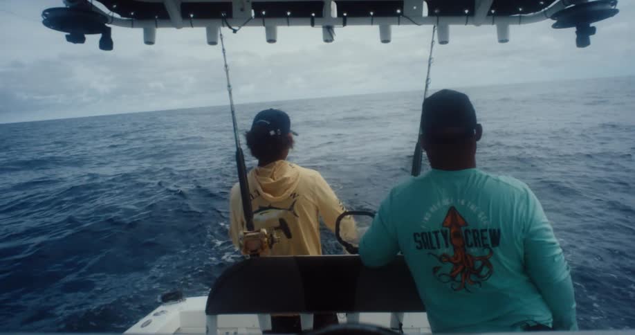 Reeling in a fish while fishing from a boat in the ocean