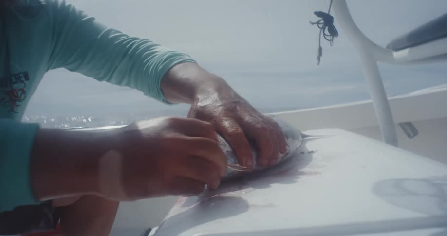 A man is removing string from a fish