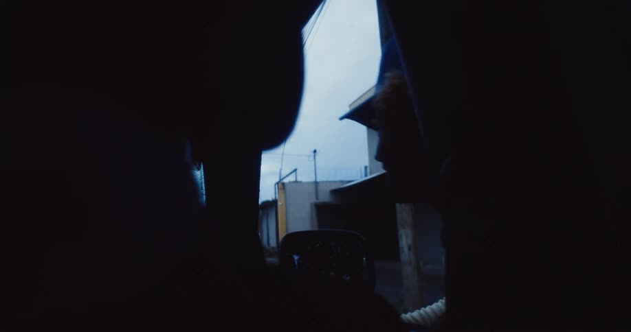A man leans in and out of the car window