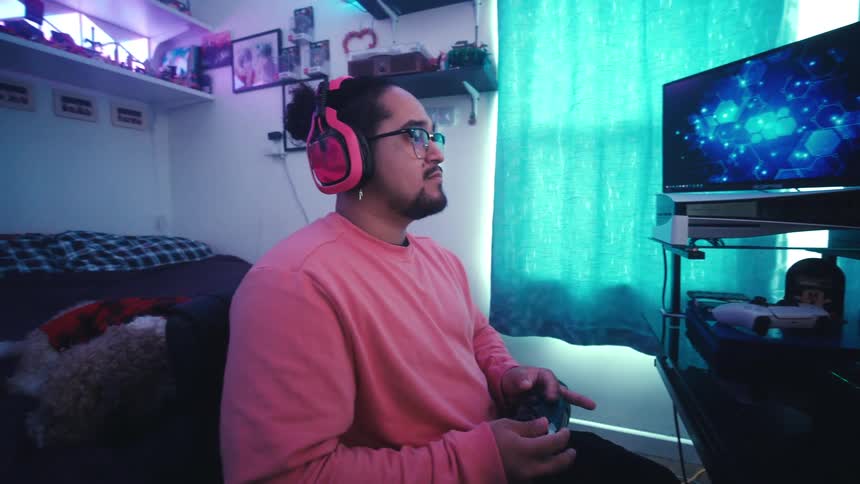 Man with headphones sitting focused playing on a gamer setup