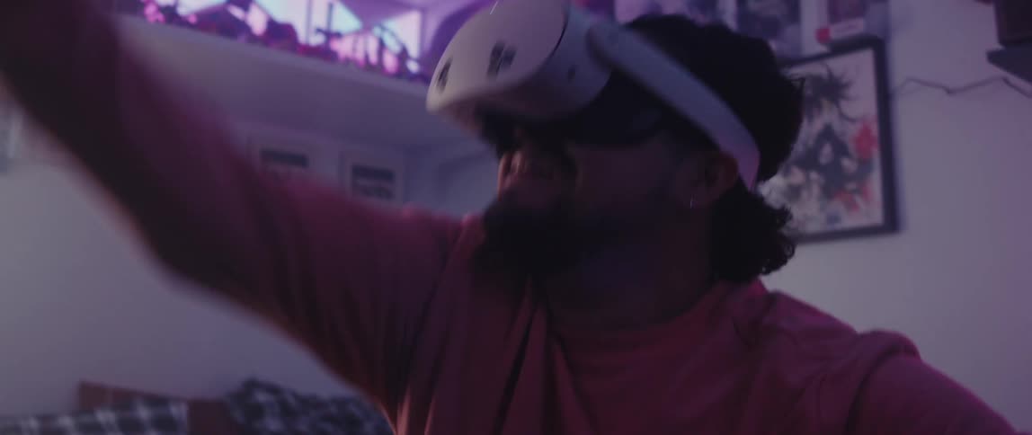 A man is swinging his arms while using a virtual reality headset
