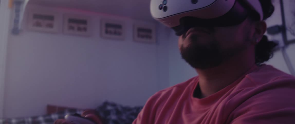 Person holding a controller and using virtual reality glasses