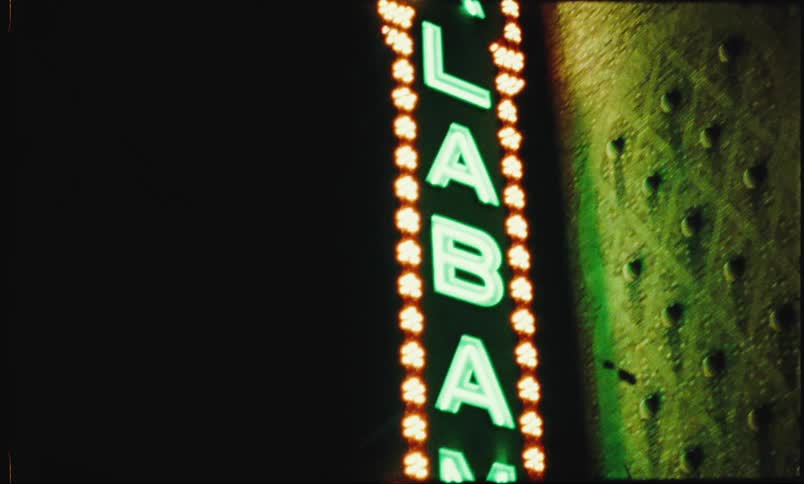 Closeup of a business sign at night with the name alabama in lights