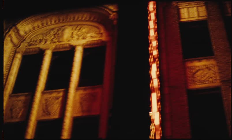 Moving view of a classic building with an illuminated sign at night