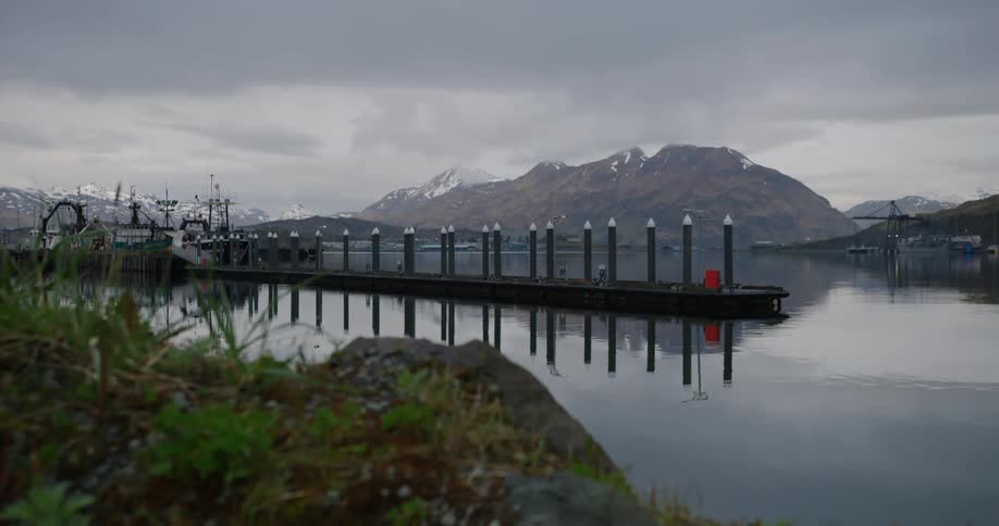 Pier on the sea with snowy mountains in the background