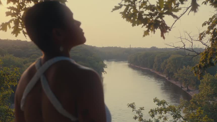 Woman outdoors in a green area with a sea canal in the background