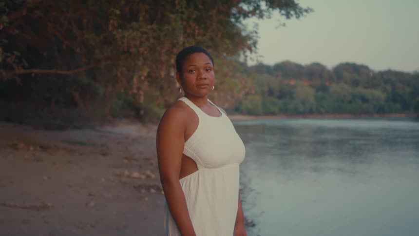 A woman is standing on the shore line