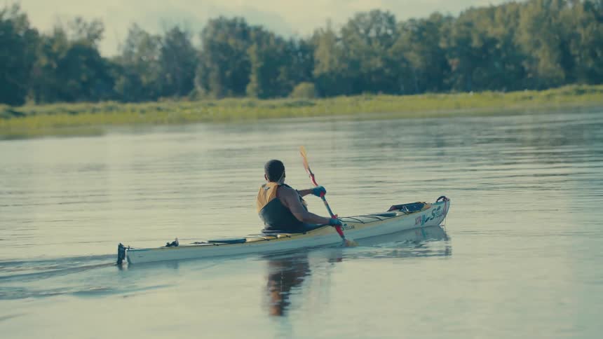 Person paddling a canoe on a river