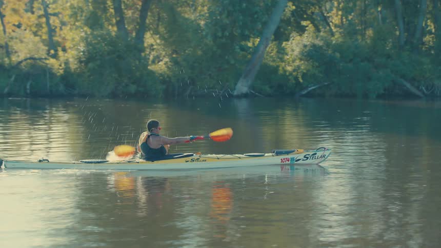 Person canoeing on a river during the day