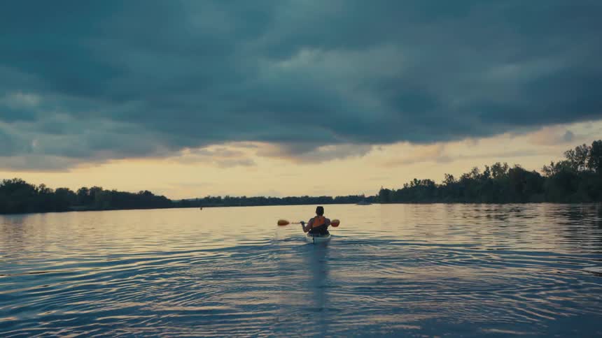Lone person canoeing on a wide river