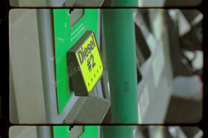 The image shows a closeup of a green fuel pump with a yellow label indicating diesel 2