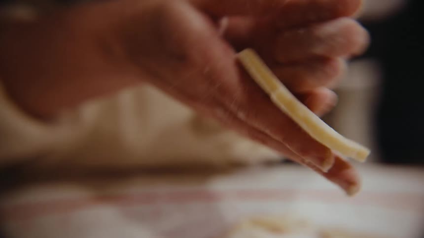 A person puts cookie dough on the baking sheet