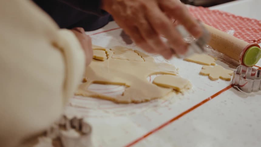 Two hands with molds cutting small candy masses