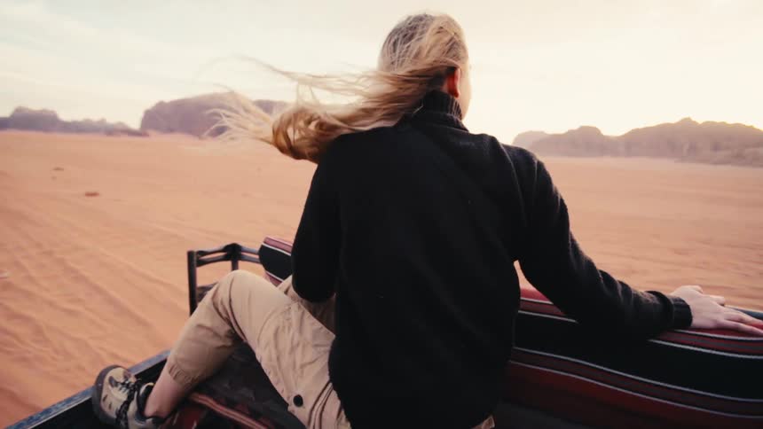 Woman sitting in a moving vehicle through a natural area