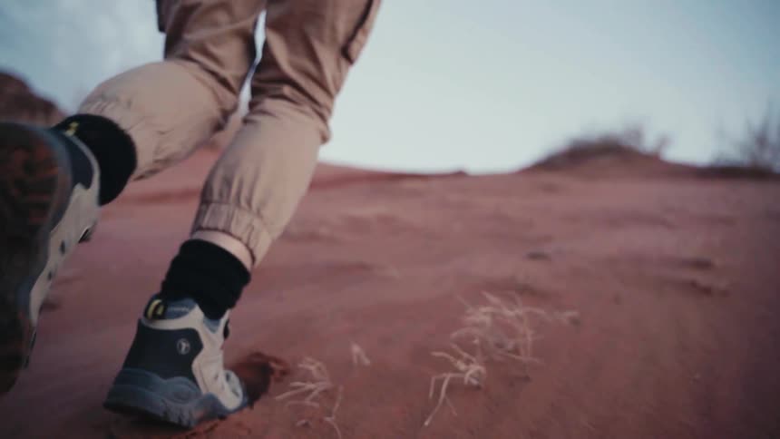 Legs of a person walking up the desert