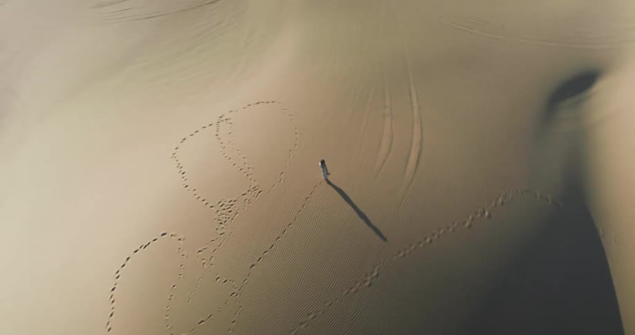 An orbiting clip of a person walking in the desert