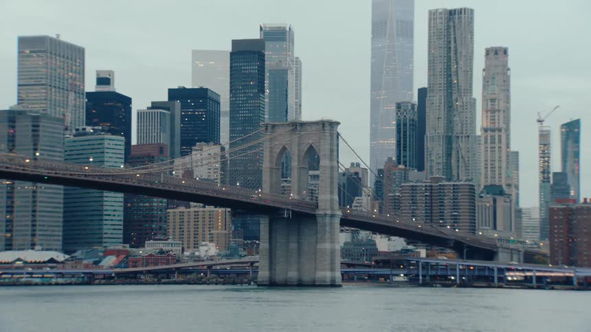 The iconic brooklyn bridge spanning the east river with its majestic towers and intricate suspension cables against the backdrop of a dense cityscape filled with towering skyscrapers